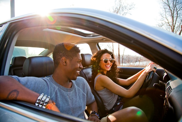 Couple smiling inside a car.