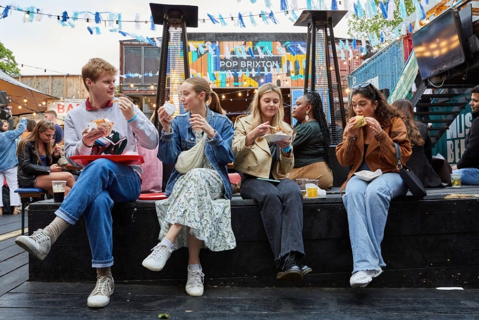 A group of people enjoying food and drinks sitting outside Food Fest