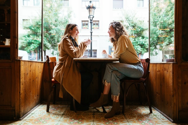 Two people sitting in a cafe in Paris near the window.