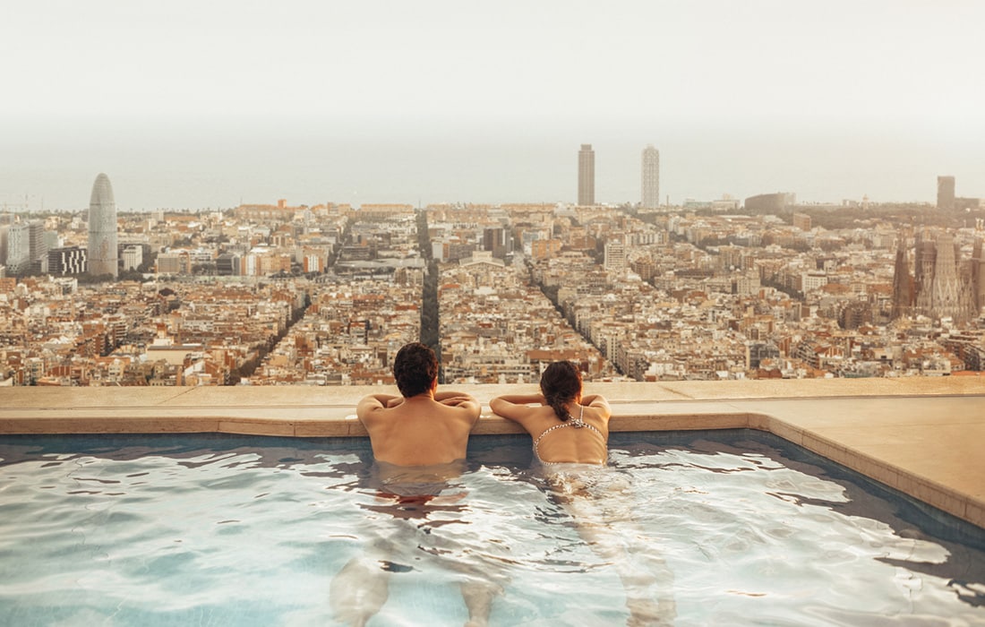 A couple on a rooftop swimming pool in Barcelona.