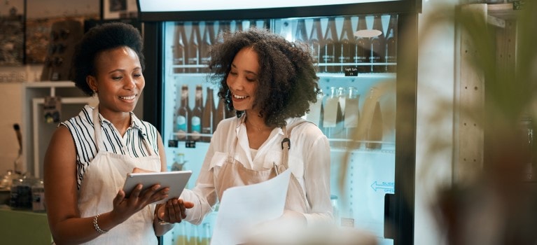 Two people working at a cafe and laughing together