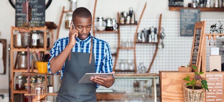 Business owner staring at a tablet while taking a call