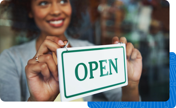 A small business owner placing the Open sign in window