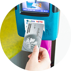 Subway turnstile screen displaying the OMNY logo, a contactless symbol, and the words "tap here"