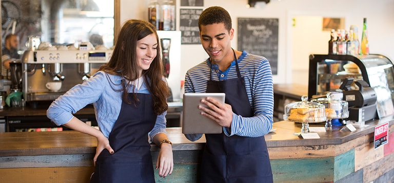 Employees in cafe holding tablet                 