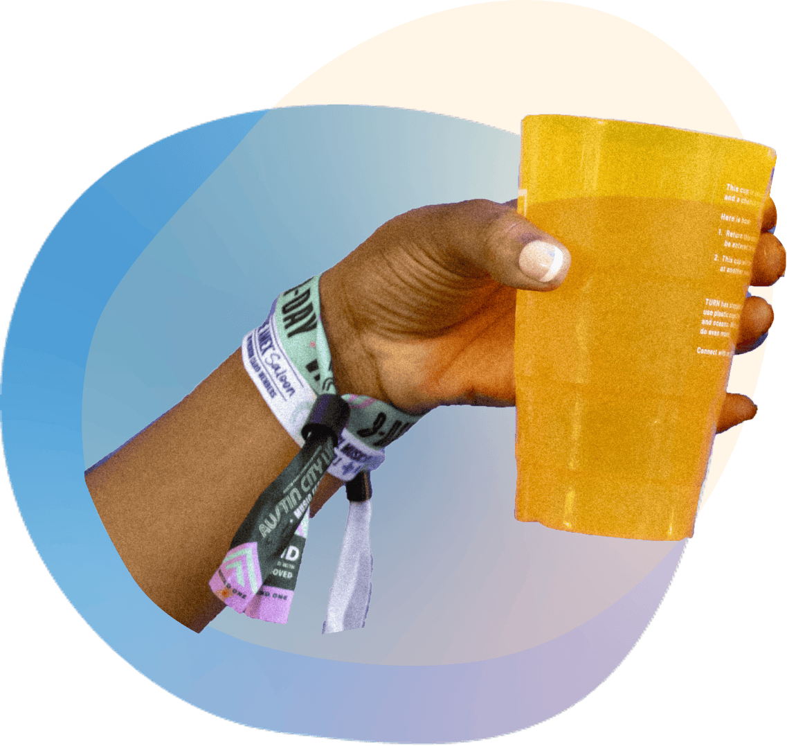 Hand with ACL wristbands holding a beverage