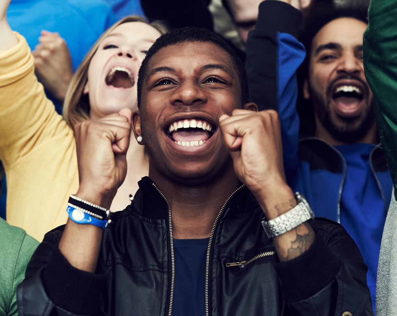 A photograph of four friends laughing and having a fun time at a music festival.