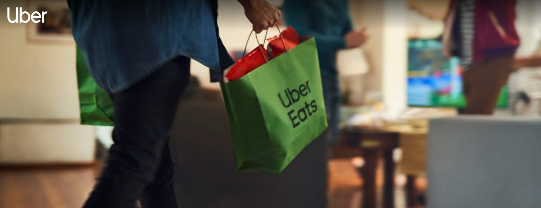 Hand carrying an Uber Eats branded bag