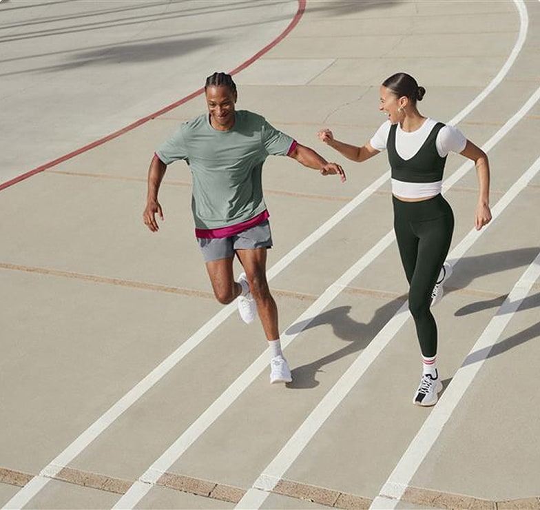 Couple playfully running on an indoor track