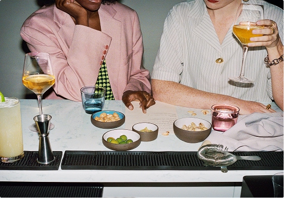 Two people eating and drinking inside at a table