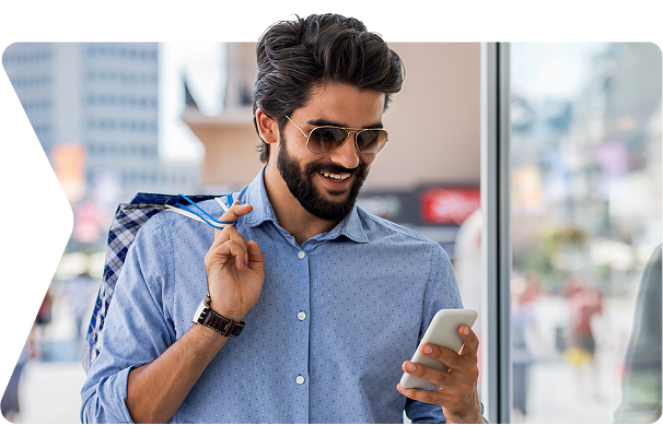 Person looking at their phone holding a shopping bag