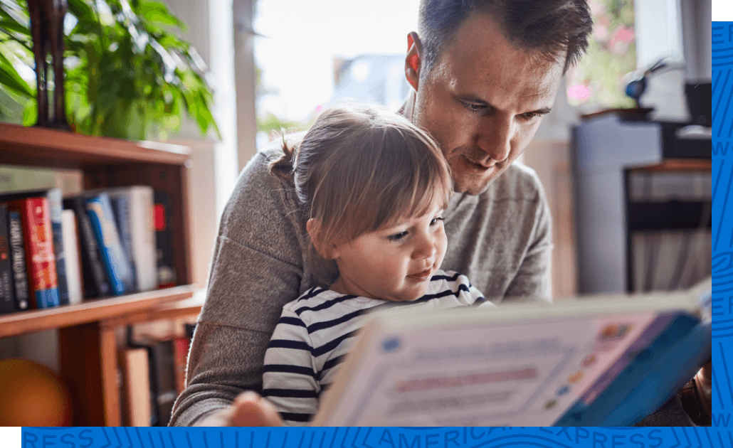 A father reads a book he purchased from Amazon.com to his child.