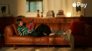 Person laying on couch looking and using iPad