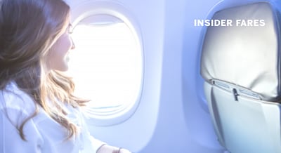 woman smiling and looking out of airplane window