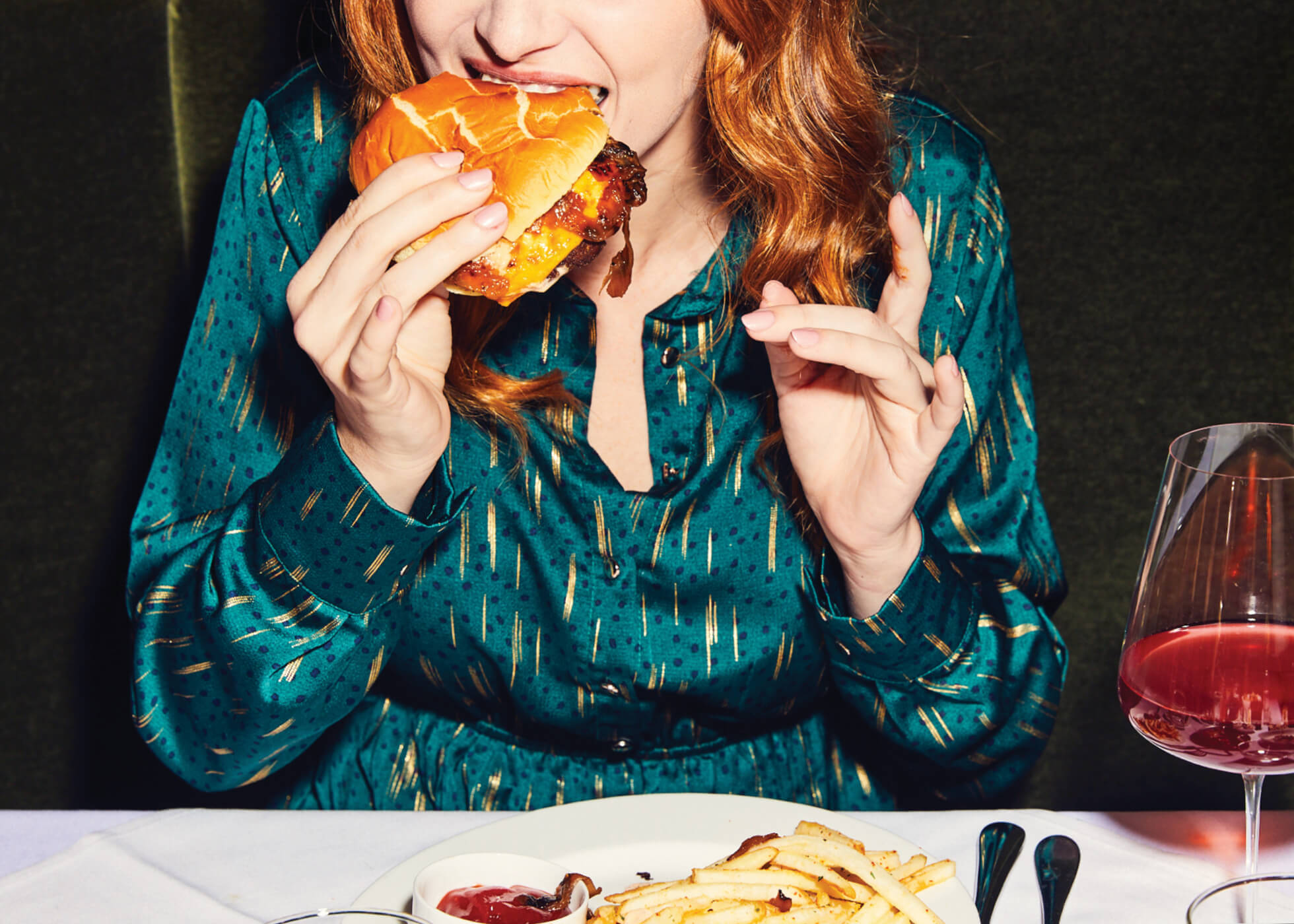 Woman eating a cheeseburger in a restaurant