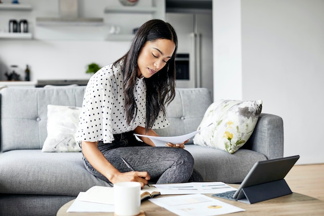 Woman writing down information in her living room