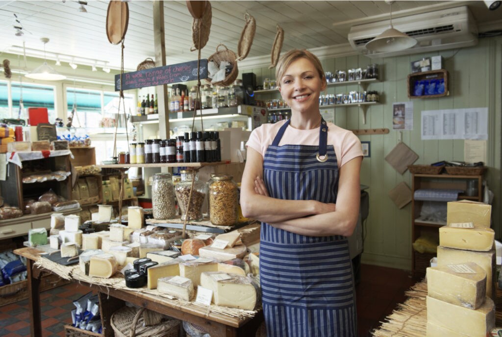 Woman business owner standing in her nuts & cheese store.