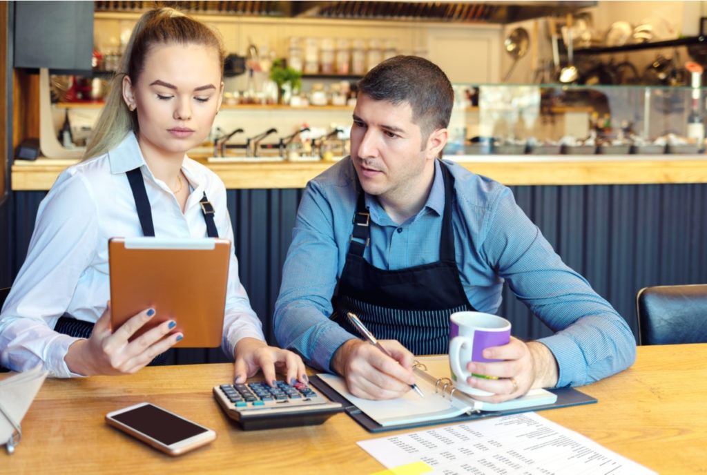 Man and Woman looking at business details on ipad.