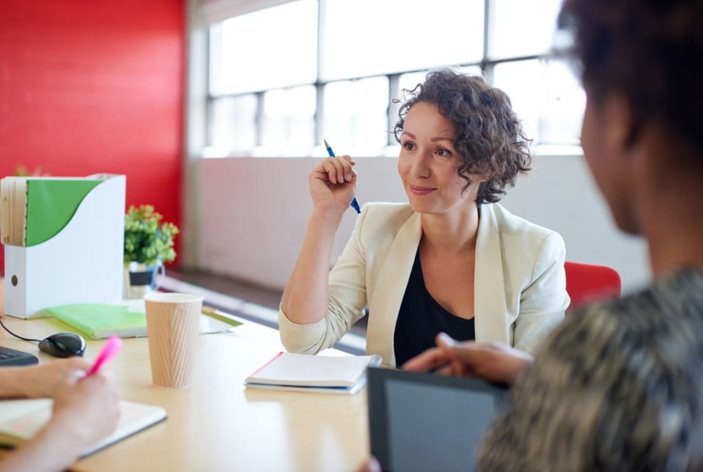 Woman smiling having conversation with employees.