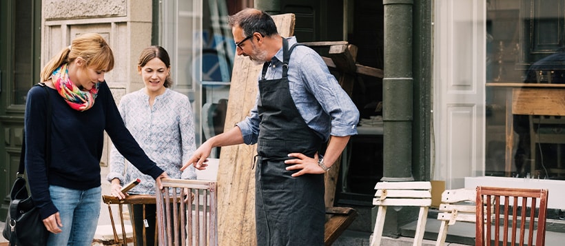 A business owner shows his chairs off to potential customers