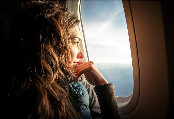 Person looking outside airplane window