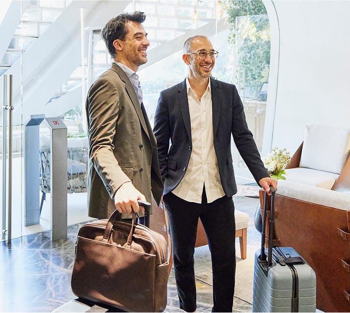 Business person with luggage using phone in airport terminal