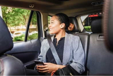 Businesswoman sitting in the backseat of a car.