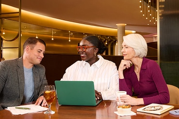 Group of three colleagues working in a lounge.