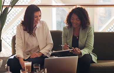 Two women working together in lounge.