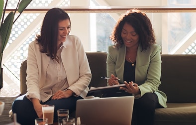 Two women working together in lounge.