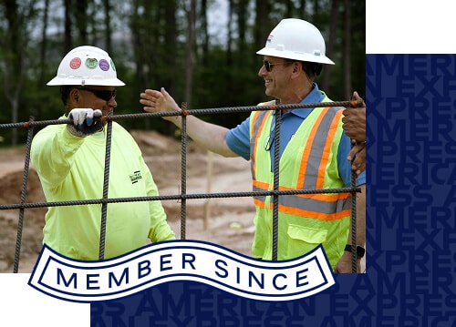 Two construction workers having a conversation next to a wire fence