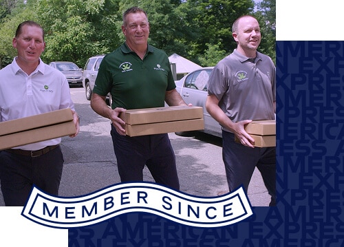 Two employees walking side-by-side carrying flat boxes