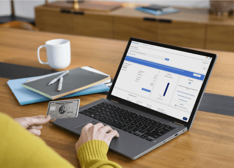 Hand tapping on laptop while holding an American Express Card