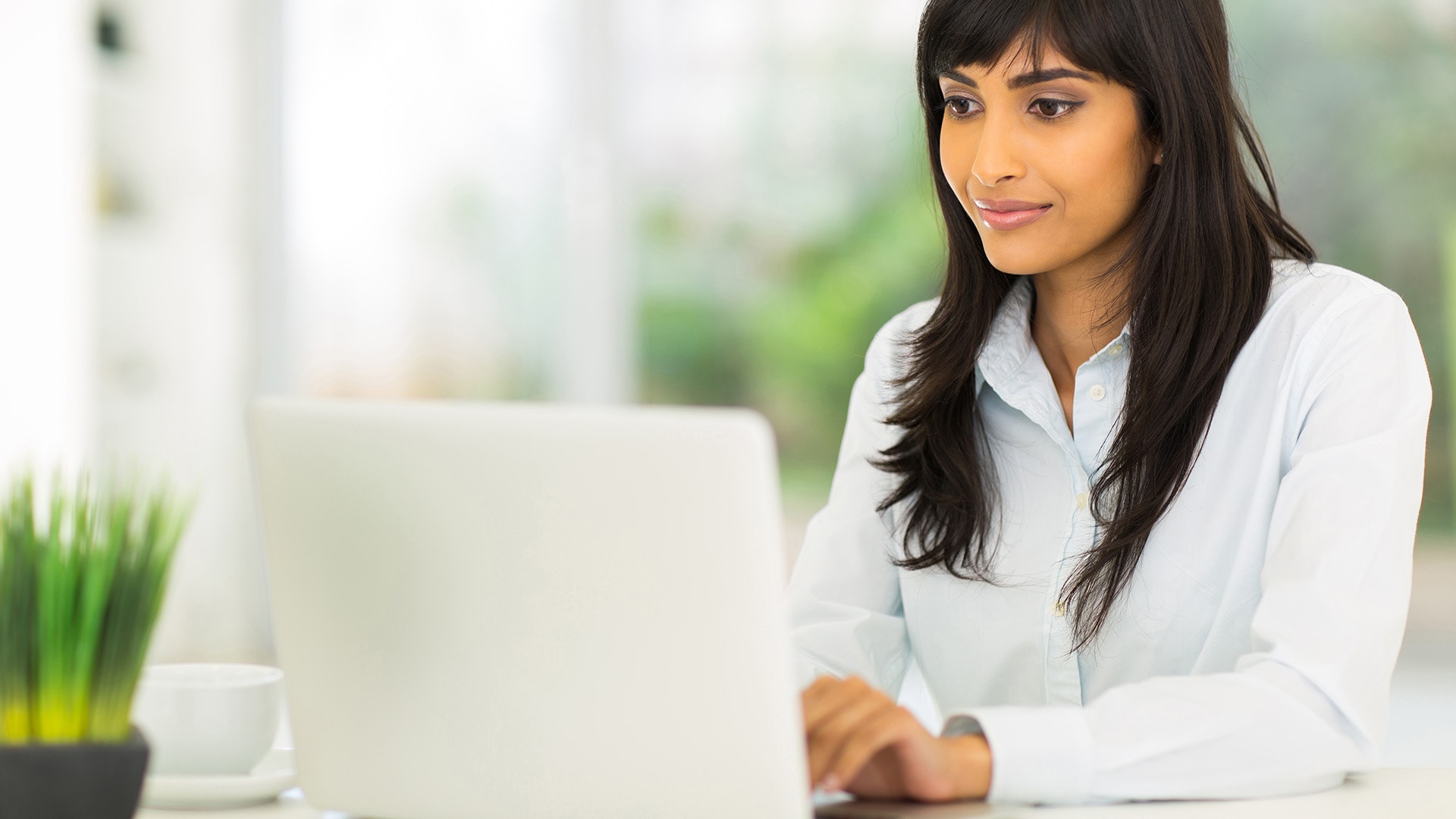 Woman sitting at her desk typing on her computer