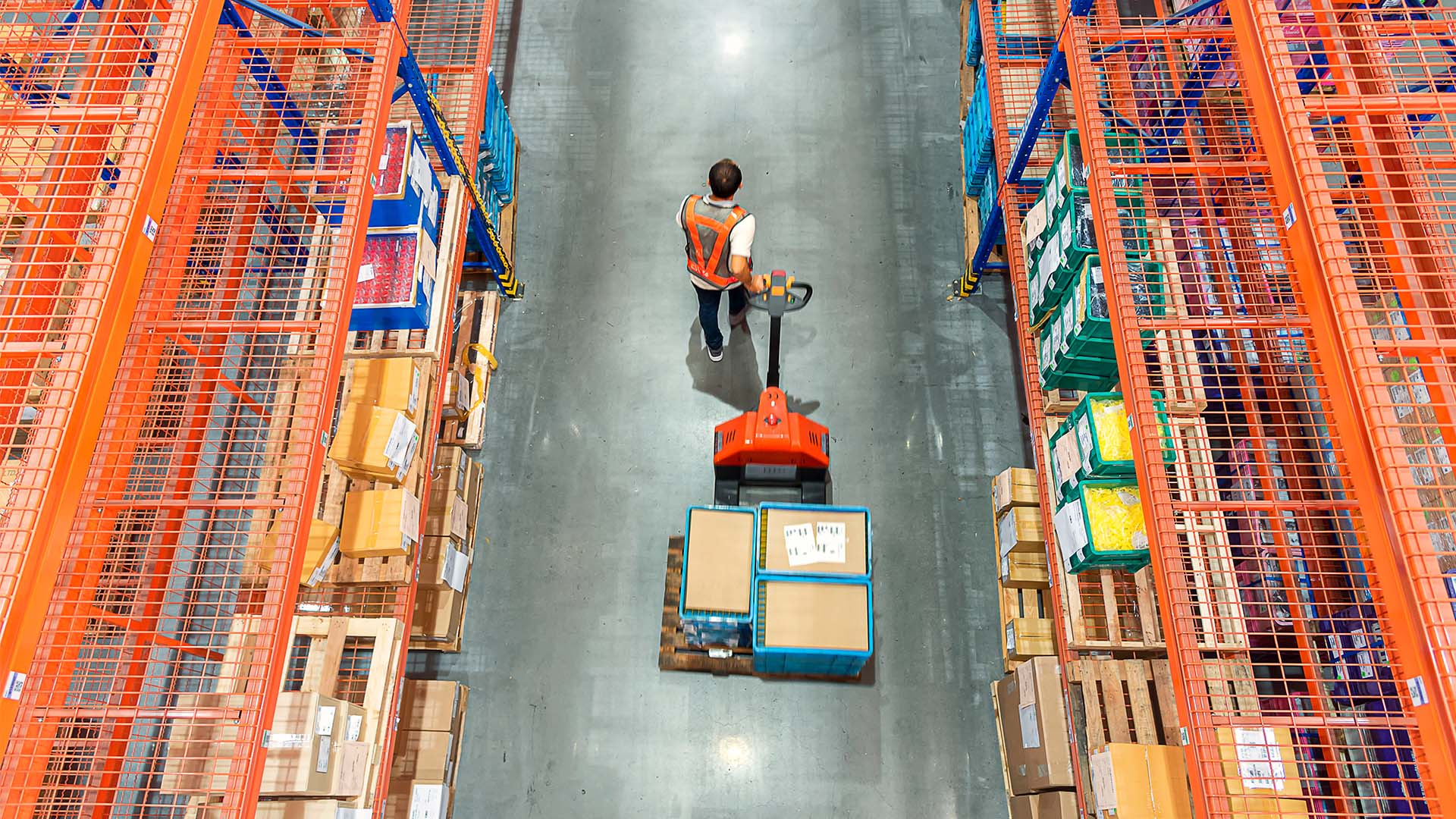 Man at warehouse pulling boxes on a dolly