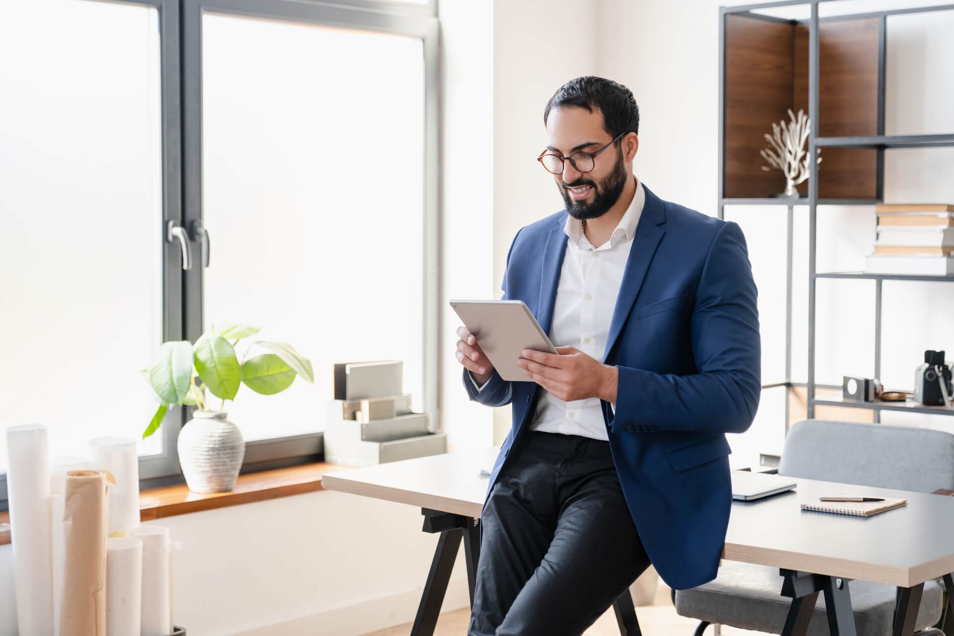 A businessman carefully studies his tablet.