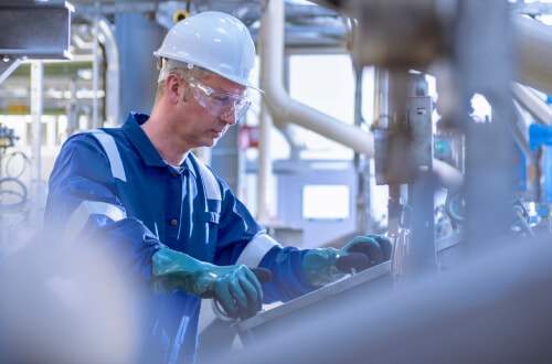 Man in hard hat monitoring pipelines