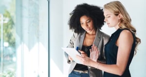 Two women working on tablet in office