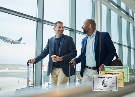 Two men with suitcases walking through airport talking to each other