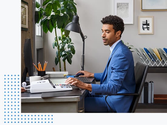  Man sitting at office desk and typing numbers while looking at desktop