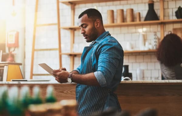 Small business owner standing at counter and looking at documents