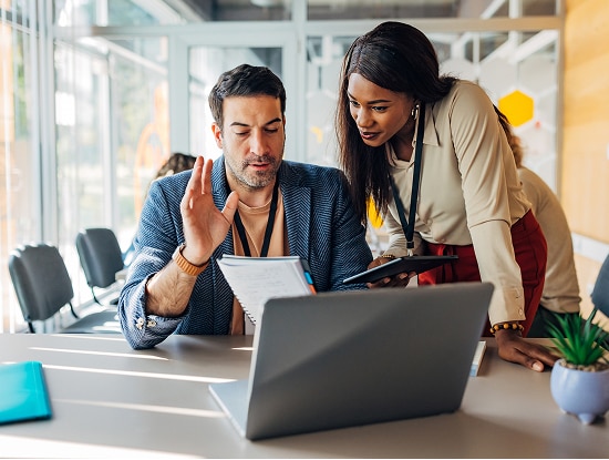  Two coworkers in a conference room looking at documents