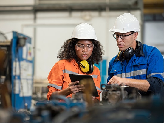  Two warehouse workers looking at a tablet device