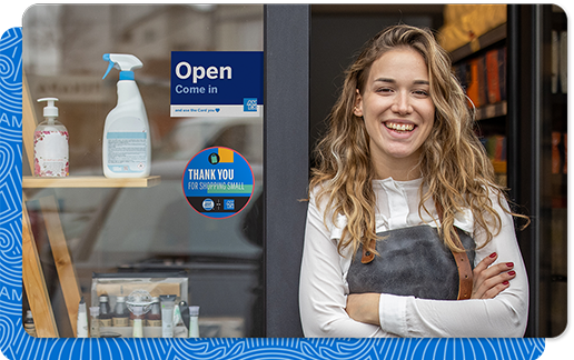 Woman standing in storefront of salon with AMEX signage in storefront window