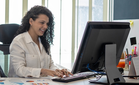 Smiling woman in office working on a computer