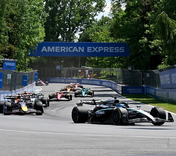 F1 race cars with fans cheering