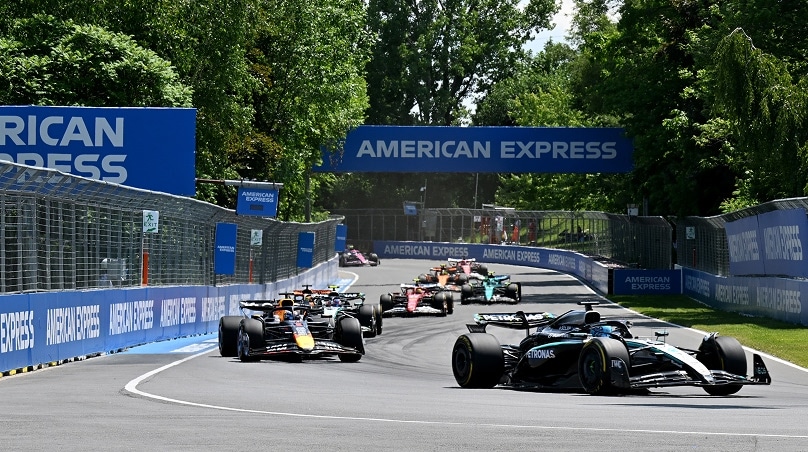 F1 race cars with fans cheering