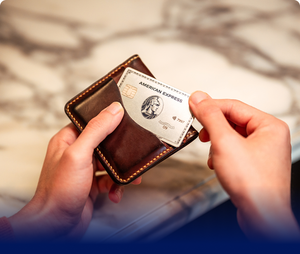 Hand putting an American Express Platinum Card into a wallet