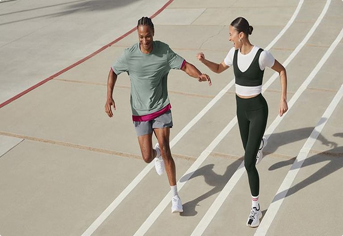 Couple playfully running on an indoor track