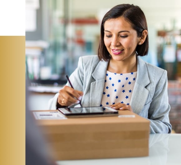 Woman receiving package and signing off on tablet.
